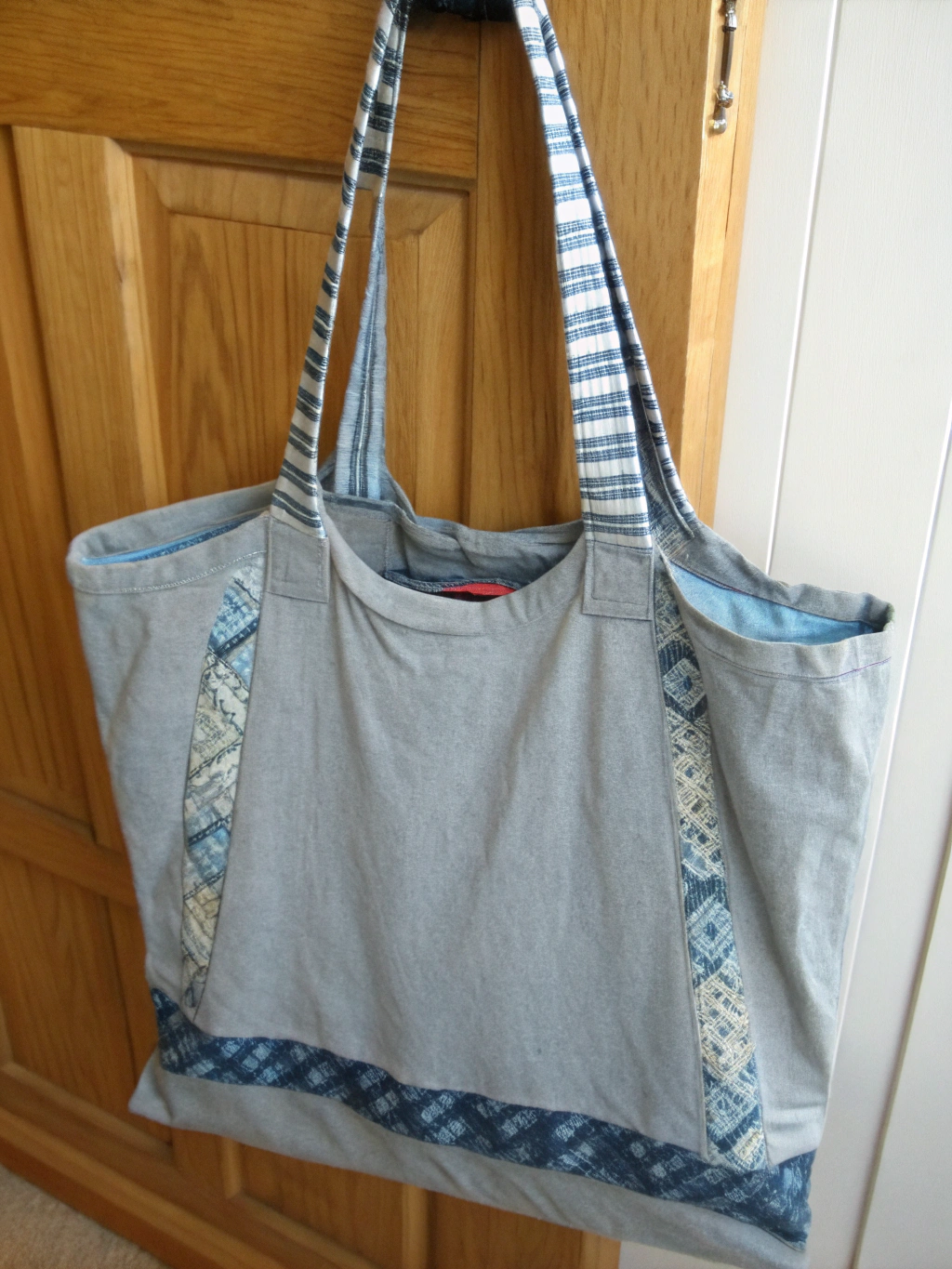 A collection of finished no-sew upcycled t-shirt projects, like a tote bag, headband, and t-shirt yarn, displayed attractively.