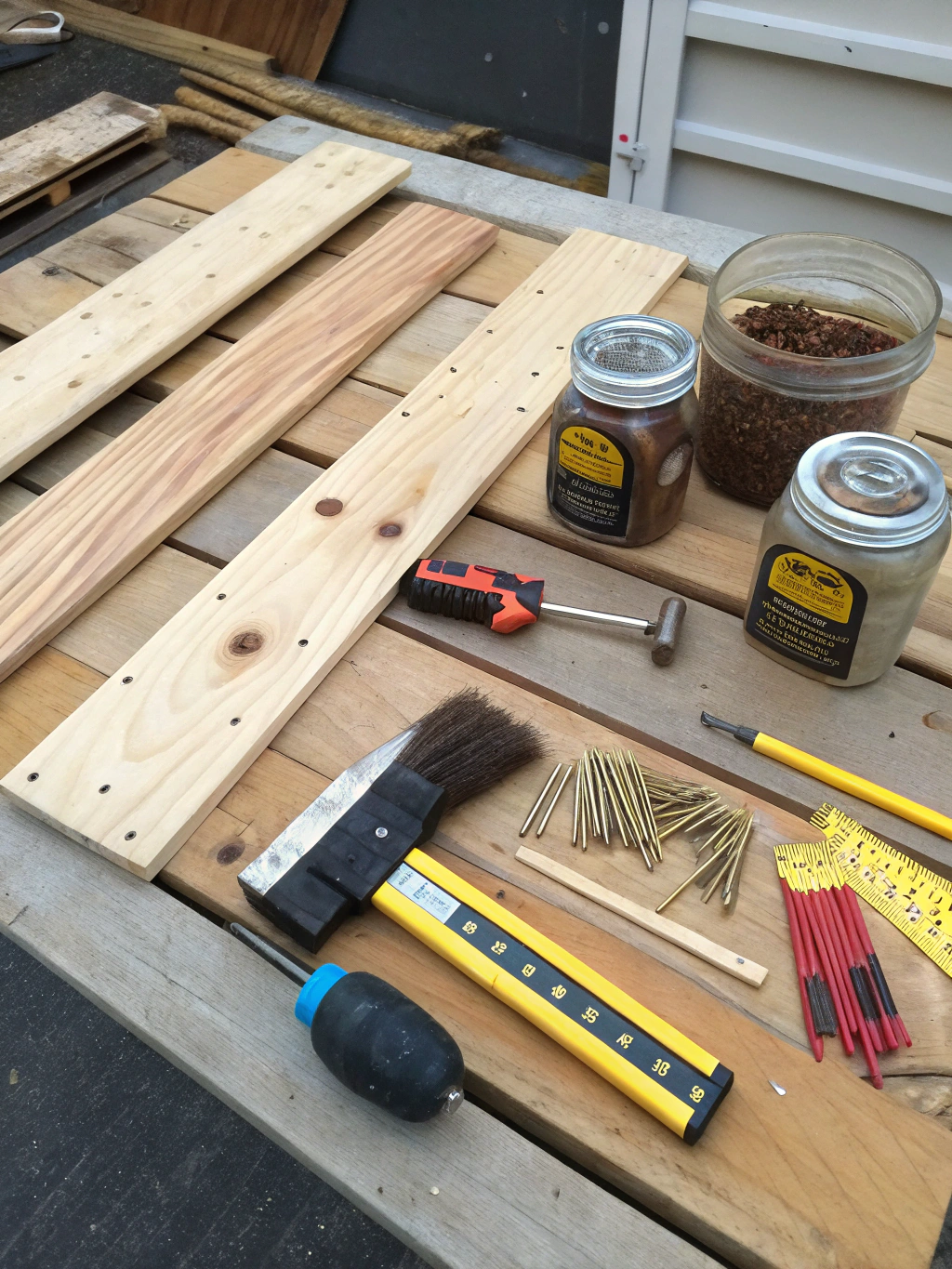 How to Craft a DIY Rustic Coffee Table: 5 Easy Steps 2 An organized flat-lay of all the tools and materials needed for the project, including wood planks, a drill, a saw, screws, and wood stain.